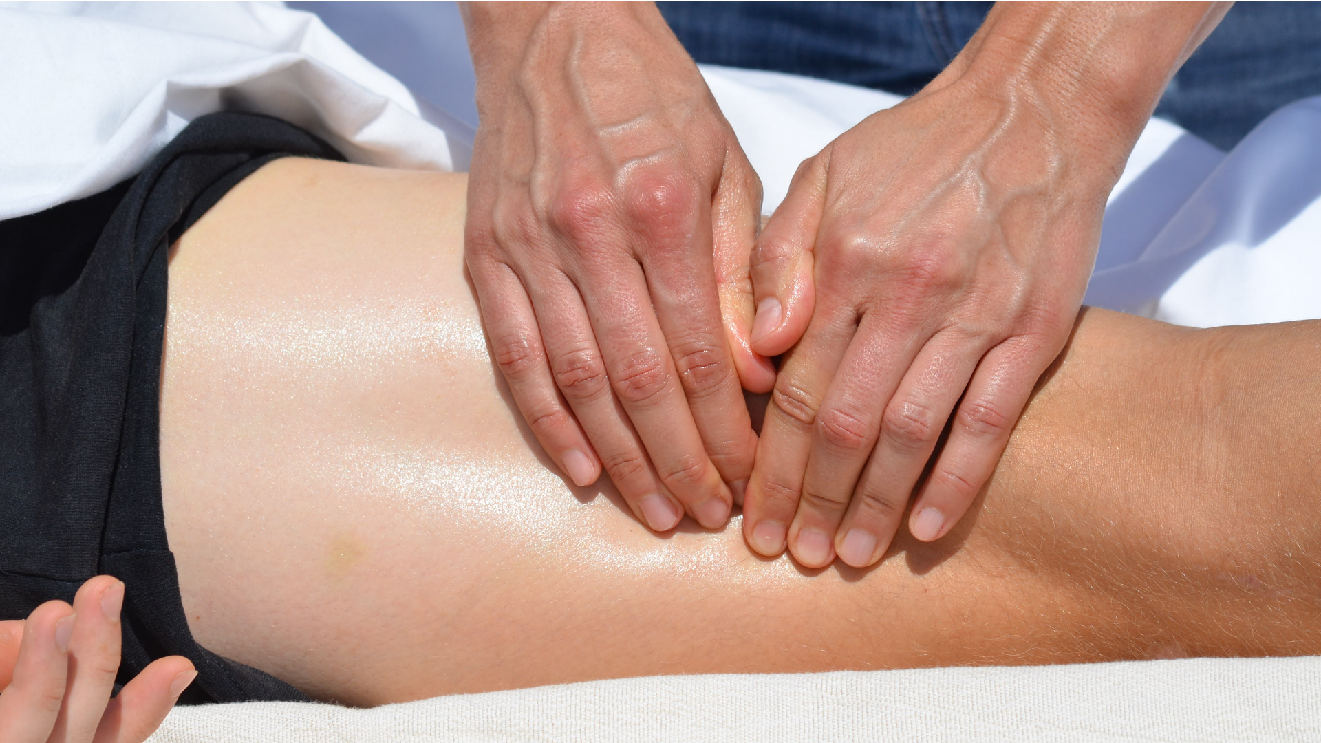 Massage de la cuisse par pression et lissage, avec les deux mains